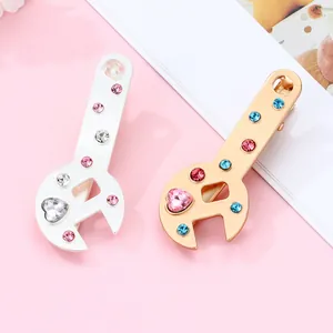 Detailed macro of wrench-shaped hair clips with colorful rhinestones in gold and silver