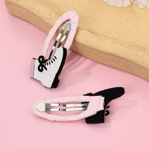 Detalle de pinzas para el pelo con forma de patines con cinta rosa y purpurina