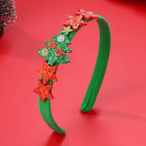 Dettaglio cerchietto di Natale con albero glitterato verde e stelle rosse su sfondo rosso