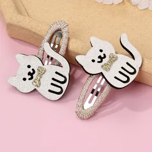 Detail of white glitter cat hair clips with golden sequin bows and woven metal BB clips