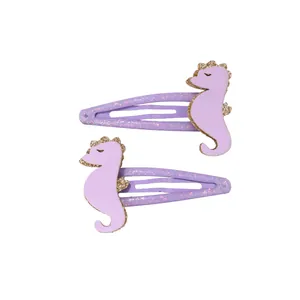 Détail de pinces à cheveux hippocampe violettes avec paillettes dorées et clip en métal