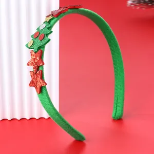 Dettaglio cerchietto albero di Natale con stelle glitterate su sfondo rosso festivo