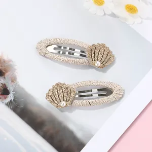 Detail of fabric wrapped BB hair clips with gold glitter shells and white pearls