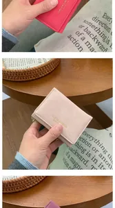Détail de portefeuilles minimalistes à trois volets pour femmes en rouge rose et violet