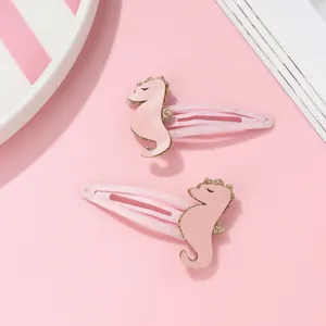 Détail de barrettes hippocampe roses à paillettes avec bords dorés pour enfants