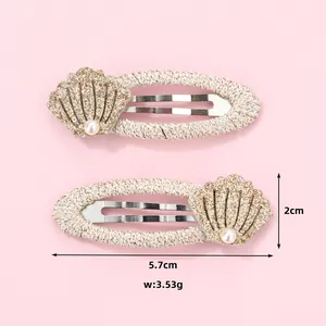 Detail showing shell and pearl accents on 5.7cm woven beige hair clips for girls