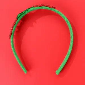 Dettaglio del cerchietto natalizio con tessuto in velluto verde e motivi in feltro rosso-verde
