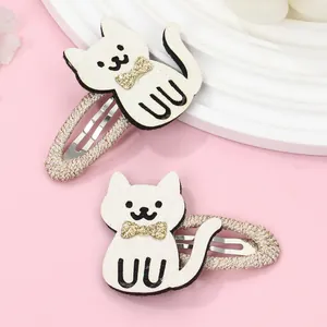 Cartoon white cat hair clips with gold sequin bows on pink decorative background