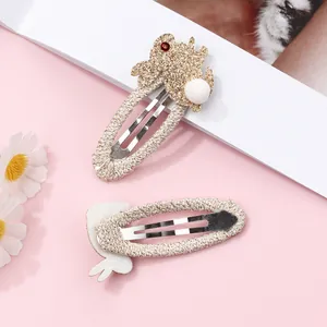 Detail of glitter rabbit hair clips and gold woven fabric texture for girls