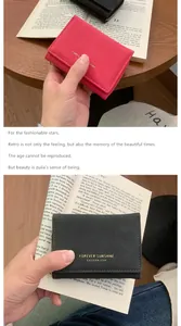 Gros plan de portefeuilles en cuir mat rouge et gris avec gravure dorée Sunshine