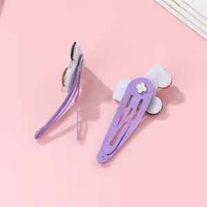 Detalle de pinzas para el cabello de metal morado con adornos de patines de fieltro