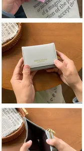 Detail showing the internal card slots and golden zipper coin pocket of the grey wallet