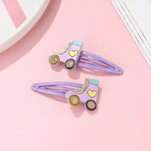 Detalle de pinzas para el pelo de patines morados con purpurina y corazones