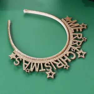 Detailed close-up of golden Merry Christmas headband with glitter stars on green surface