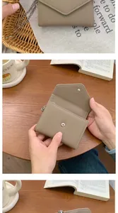 Close-up of litchi texture leather mini wallet with metal chain and envelope flap