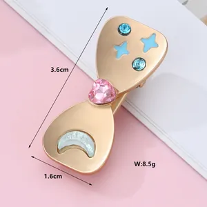 Close-up of golden hair clip with pink heart gem and star patterns, 3.6cm x 1.6cm