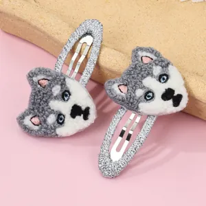 Détail de pinces à cheveux brodées en forme de husky gris avec yeux bleus et base métal
