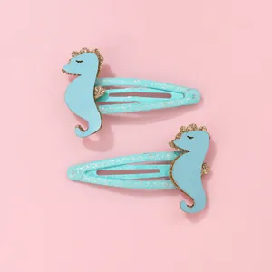 Détail de barrettes hippocampe bleues pour enfants avec paillettes dorées et clips brillants