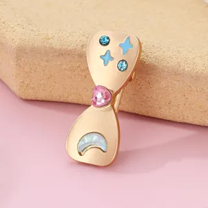 Macro shot of gold alloy heart brooch with blue star and moon crystal embellishments