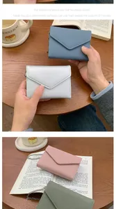 Detail showing the litchi texture and stitching on small envelope wallets in four colors