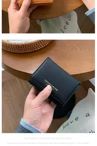 Detail of Saffiano leather wallet showing FOREVER SUNSHINE gold logo and stitching