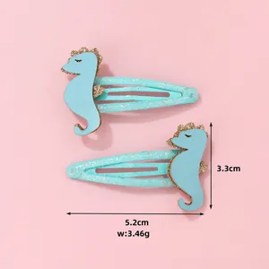Détail des barrettes hippocampe bleues avec bordure pailletée affichant la taille de 5,2 cm