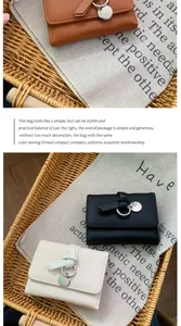 Detail of trifold wallets in litchi grain texture with knotted straps and metal charms