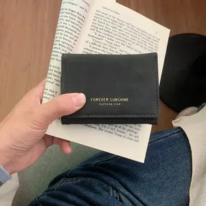 Portefeuille femme en similicuir noir à trois volets avec inscription dorée élégante