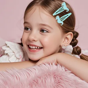 Détail des barrettes hippocampe bleu clair avec paillettes dorées sur fond rose doux