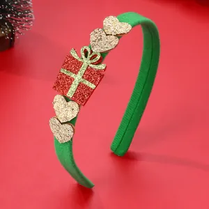 Dettaglio di cerchietto verde con confezione regalo rossa glitterata e cuori dorati