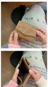Detail of khaki envelope wallet showing interior bill compartment and logo print