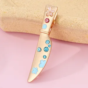 Detailed view of creative sword-shaped hair clip with gold alloy and blue floral accents