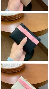 Detailed view of women's compact card wallets in black and beige with gold zippers