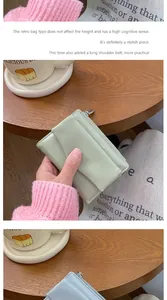 Close-up of mint green envelope card holder with Forever Sunshine logo and metal zipper