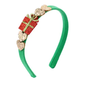 Dettaglio del cerchietto natalizio con scatola regalo rossa glitterata e cuori d'oro
