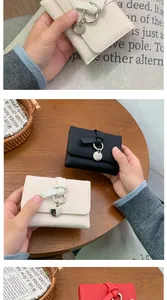 Close-up of litchi grain leather wallets with knot strap and round metal pendant