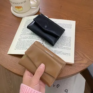 Minimalist envelope wallet in black and khaki colors displayed on a wooden desk with coffee