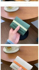 Dettaglio porta carte in pelle con trama litchi, cinturini a contrasto e cuciture precise