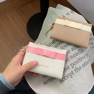 Minimalist bow-decorated card holders in cream and khaki with gold zipper and chain