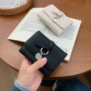 Minimalist pebble grain leather trifold wallet with decorative knot and silver pendant