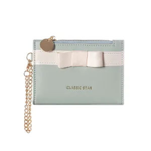 Elegant mint blue card holder with cream bow decoration and gold wrist chain