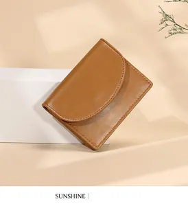 Cartera de cuero color caramelo con diseño minimalista, solapa semicircular y costuras