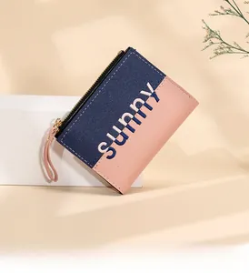 Detailed view of navy and pink patchwork wallet with zipper and sunny print