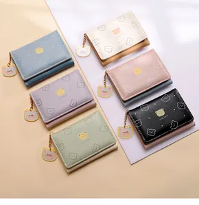 Variedad de mini carteras plegables coloridas con dibujos de osos y cadenas doradas