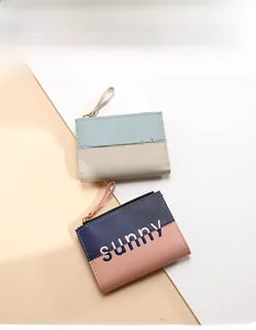 Detail of short zip wallets with sunny embroidery in two-tone contrast faux leather