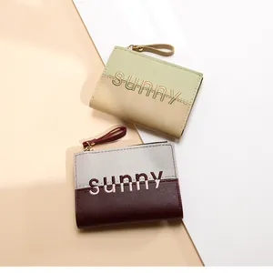 Detail of two-tone PU leather wallets featuring sunny embroidery and metal zippers