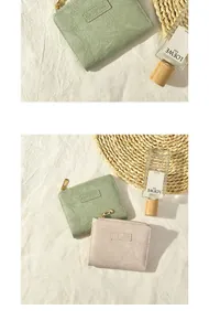 Detail of sage green and pink textured leather mini wallets with golden zippers