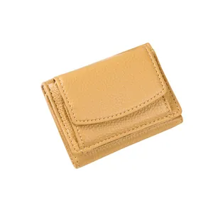 Portafoglio da donna minimalista in pelle giallo zenzero con trama litchi su sfondo bianco