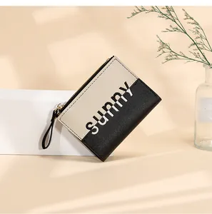 Detail view of a black and white PU leather coin purse with sunny print and gold zipper