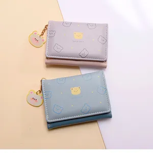Detalle de carteras de cuero PU azul y morado con estampados de osos y colgantes a juego